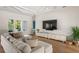 Bright living room featuring a large sectional sofa and modern entertainment center at 705 N Lake Sybelia Dr, Maitland, FL 32751