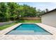 Beautiful backyard featuring a pool with paver deck, green grass, and mature trees at 705 N Lake Sybelia Dr, Maitland, FL 32751