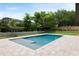 Backyard view of the pool with paver deck, green grass and mature trees at 705 N Lake Sybelia Dr, Maitland, FL 32751