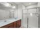 Bathroom featuring double sinks, quartz countertops and glass enclosed shower at 714 Golden Elm Dr, Apopka, FL 32703