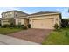 Attractive single-story home with a brick paved driveway and well-maintained landscaping at 714 Golden Elm Dr, Apopka, FL 32703