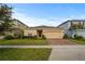 Charming single-story home with a well-manicured lawn and brick-paved driveway leading to an attached two-car garage at 714 Golden Elm Dr, Apopka, FL 32703