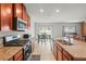 Open kitchen with island, granite countertops, stainless steel appliances, and tile floors at 714 Golden Elm Dr, Apopka, FL 32703