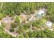 Aerial view of a peaceful, secluded property with a pond, large buildings and surrounded by dense trees at 723 River Run Rd, Osteen, FL 32764