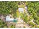 Aerial view of a serene property with well-maintained home, lush trees, and outbuildings at 723 River Run Rd, Osteen, FL 32764