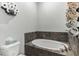 Modern bathroom featuring a soaking tub with slate tile and decorative towel arrangements at 723 River Run Rd, Osteen, FL 32764
