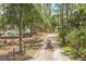 Long gravel driveway leading to a secluded property with mature trees, fencing, and lush greenery at 723 River Run Rd, Osteen, FL 32764
