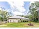 Well-maintained home featuring a metal roof, small garden, and green lawn at 723 River Run Rd, Osteen, FL 32764