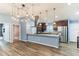 An open-concept kitchen features stainless steel appliances, wood cabinets, and modern pendant lighting at 723 River Run Rd, Osteen, FL 32764