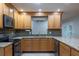 Well-lit kitchen featuring wooden cabinets, granite countertops, and modern stainless steel appliances at 789 Barger Dr, Deltona, FL 32738