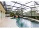 Screened-in pool area featuring lush landscaping and a charming rock waterfall feature at 789 Barger Dr, Deltona, FL 32738