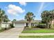 Inviting single-story home featuring a lush front yard, mature palms, and a convenient two-car garage at 826 Bright Meadow Dr, Lake Mary, FL 32746