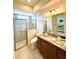 Well-lit bathroom featuring glass enclosed shower, granite vanity, and modern fixtures at 871 Iron Oak Way, The Villages, FL 32163