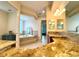 Bathroom with a luxurious soaking tub, granite countertops and a view to the bedroom at 871 Iron Oak Way, The Villages, FL 32163