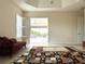 Bright living room with neutral walls, large windows, and a door leading to a covered patio at 871 Iron Oak Way, The Villages, FL 32163