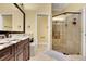 Bathroom featuring granite counters, dark wood cabinetry, dual sinks, and walk-in shower with glass door at 914 Sweetgum Valley Pl, Lake Mary, FL 32746