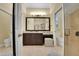 Bathroom with dual sinks, dark wood cabinetry, granite counters, walk-in shower, and separate toilet room at 914 Sweetgum Valley Pl, Lake Mary, FL 32746