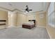 Large bedroom with carpet, tray ceiling, ceiling fan, and ample natural light from multiple windows at 914 Sweetgum Valley Pl, Lake Mary, FL 32746