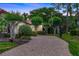 Long brick paved driveway leading up to a home surrounded by lush, mature landscaping at 914 Sweetgum Valley Pl, Lake Mary, FL 32746