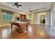 Well-lit game room with hardwood floors, a pool table, a wet bar, and access to the patio at 914 Sweetgum Valley Pl, Lake Mary, FL 32746