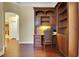 Home office with hardwood floors, custom built-in desk and shelving, with views of the kitchen and hallway at 914 Sweetgum Valley Pl, Lake Mary, FL 32746
