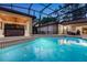 Beautifully lit pool and spa area with screened enclosure and adjacent covered lounge area at 914 Sweetgum Valley Pl, Lake Mary, FL 32746