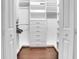 Organized walk-in closet featuring built-in shelving, drawers, and hardwood flooring at 914 Sweetgum Valley Pl, Lake Mary, FL 32746