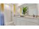 Bathroom featuring double sinks, white cabinets, and a walk-in shower with a yellow curtain at 939 Princess Sabal Pt, Haines City, FL 33844
