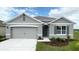Charming gray single-Gathering home boasts a well-manicured lawn and a two car garage at 943 Princess Sabal Pt, Haines City, FL 33844