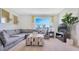 Bright living room with plush gray sectional couch, ottoman, and television at 939 Princess Sabal Pt, Haines City, FL 33844