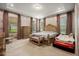 Spacious bedroom with patterned wallpaper, large windows, dresser, sitting bench and king bed at 9567 Meadow Hunt Way, Winter Garden, FL 34787