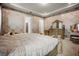 Spacious bedroom features patterned wallpaper, wooden dresser and king bed with ensuite bathroom at 9567 Meadow Hunt Way, Winter Garden, FL 34787