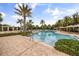 Inviting community pool surrounded by palm trees and well-manicured landscaping on a beautiful sunny day at 9567 Meadow Hunt Way, Winter Garden, FL 34787