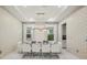Stylish dining room with modern chandelier, seating for eight, and elegant wallpaper at 9567 Meadow Hunt Way, Winter Garden, FL 34787
