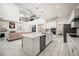 Modern kitchen includes stainless steel appliances, white cabinets, a center island and tiled floors at 9567 Meadow Hunt Way, Winter Garden, FL 34787