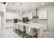 Bright modern kitchen boasts white cabinetry, stainless steel appliances, an island with seating and decorative lighting at 9567 Meadow Hunt Way, Winter Garden, FL 34787