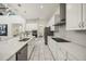 Modern kitchen featuring stainless steel appliances, white cabinets, an island with sink, and tiled flooring at 9567 Meadow Hunt Way, Winter Garden, FL 34787
