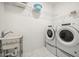 Functional laundry room with modern appliances, utility sink, and wire shelving at 9567 Meadow Hunt Way, Winter Garden, FL 34787