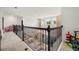 A bright loft space features a dark metal railing overlooking the floor below with a seating area and chandelier at 9567 Meadow Hunt Way, Winter Garden, FL 34787