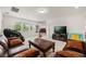 Upstairs loft is decorated with a brown leather seating set and a large television; natural light fills the space at 9567 Meadow Hunt Way, Winter Garden, FL 34787