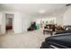 An upstairs loft features white wainscotting, leather seating, a TV, and views of the stairs, chandelier, and backyard at 9567 Meadow Hunt Way, Winter Garden, FL 34787
