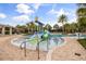 Community splash pad featuring colorful water slides, palm trees, and ample seating near the pool at 9567 Meadow Hunt Way, Winter Garden, FL 34787