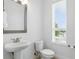 Well-lit powder room featuring a pedestal sink, toilet, and window with a view at 9820 Bucklow Hill Dr, Orlando, FL 32832