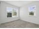 Bright bedroom with neutral carpet, base trim, and multiple windows at 9820 Bucklow Hill Dr, Orlando, FL 32832