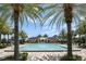 Large community pool surrounded by lounge chairs and lush palm trees at 9820 Bucklow Hill Dr, Orlando, FL 32832