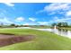 Scenic golf course view with a water hazard, fountain, and meticulously maintained green at 9820 Bucklow Hill Dr, Orlando, FL 32832