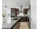 Modern kitchen featuring dark cabinets, a granite countertop, and stainless steel appliances at 9820 Bucklow Hill Dr, Orlando, FL 32832
