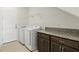 Laundry room featuring granite counter, cabinets, washer and dryer at 9820 Bucklow Hill Dr, Orlando, FL 32832