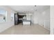 Bright living space flows into a kitchen with dark cabinetry, pendant lights, and tile flooring at 9820 Bucklow Hill Dr, Orlando, FL 32832