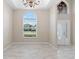 Bright foyer with arched window, modern chandelier, and light neutral color palette at 9885 Montclair Circle Cir, Apopka, FL 32703